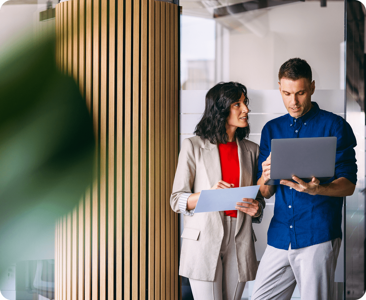 Colleagues discussing work with a laptop