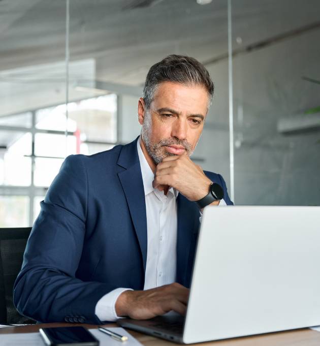 Man in suit working on laptop.